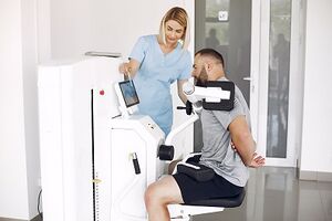 Patient-doing-exercise-using-quipment-with-therapist.jpg